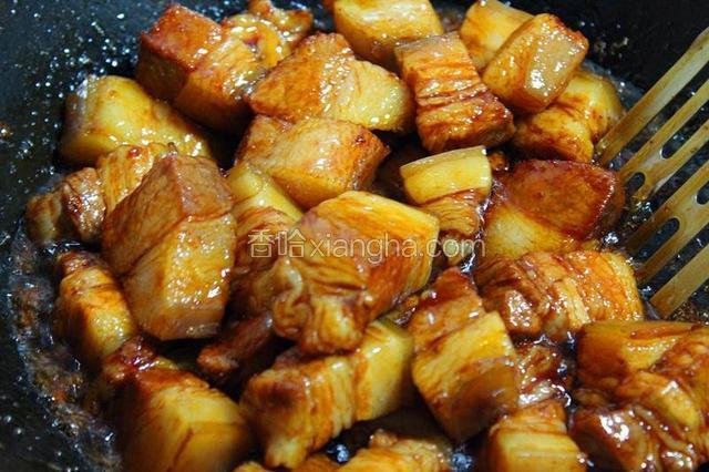将五花肉倒入锅内，转中火。快速翻炒。让每块五花肉都裹上糖色。

