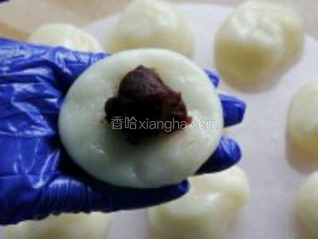 
取一份，按成圆饼，放入豆沙，揉成圆球。