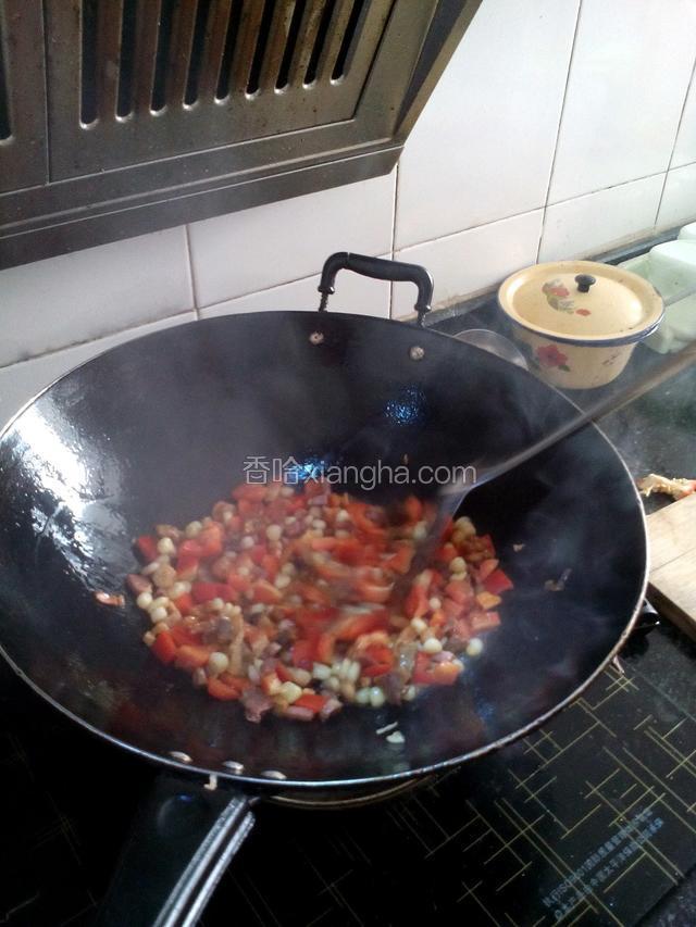 把切成丁的红椒，腊肉放在锅里翻炒