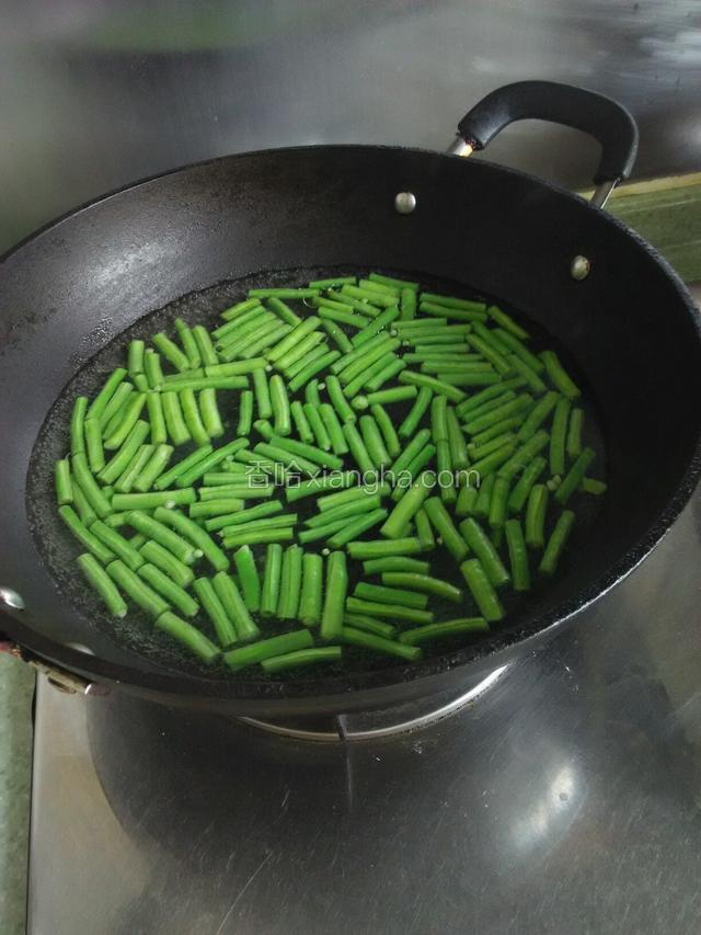 放入豇豆，倒入几滴植物油，把豇豆焯熟。