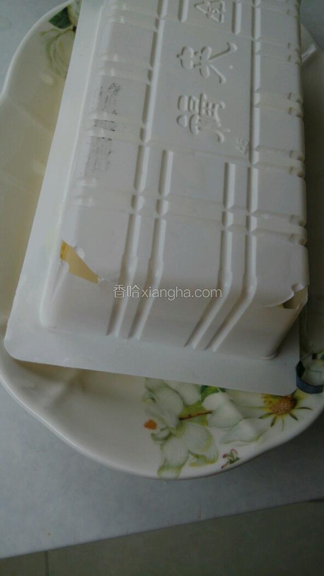 把内酯豆腐从盒里倒出来，如果想要完整的豆腐，用剪子在盒的四个角上剪个小洞就行