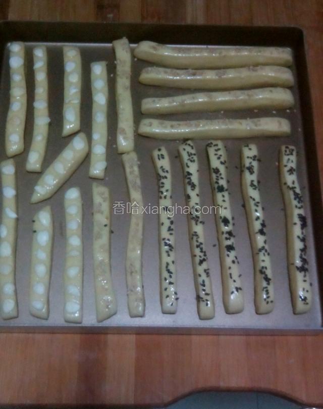 切好的长条放不粘烤盘，入烤箱发酵30分钟左右，最底层放一碗水。
发酵好取出刷全蛋液，撒上杏仁和芝麻。