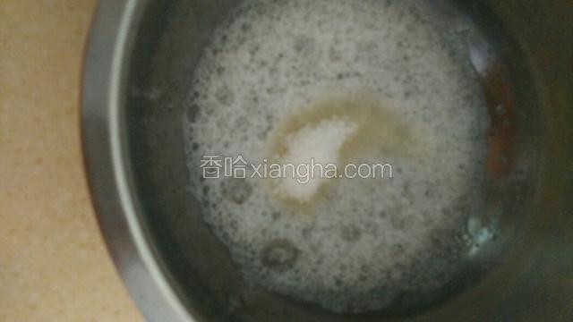 蛋白霜的打发。糖分三次加。用打蛋器将蛋白打至由透明状转为白色打大气泡，加入第一次砂糖。如图。
ps.打蛋器要与胳膊垂直，且要贴盆打。操作不得当会破坏蛋白稳定性。蛋白霜的制作不稳定直接影响蛋糕凹，陷。