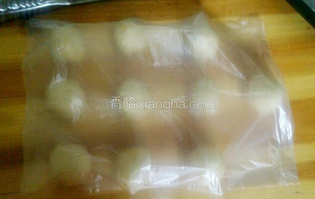 把发酵好的面团排出空气，分割成40克左右的小面团，然后滚圆，盖上保鲜膜，静置15分钟