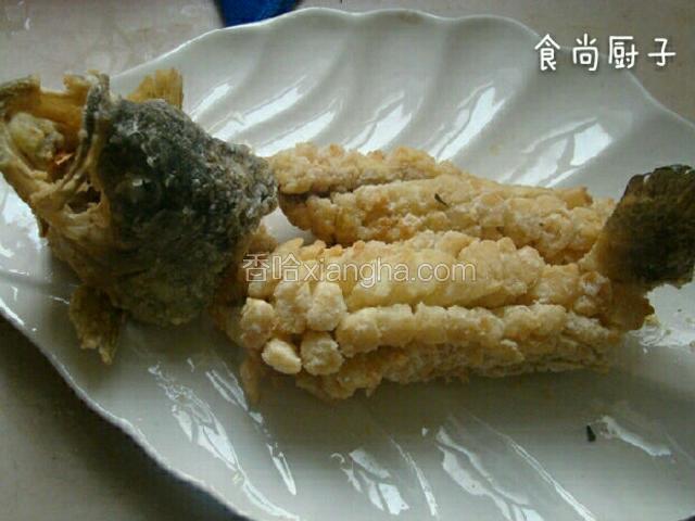 捞出沥净油摆放在盘中。