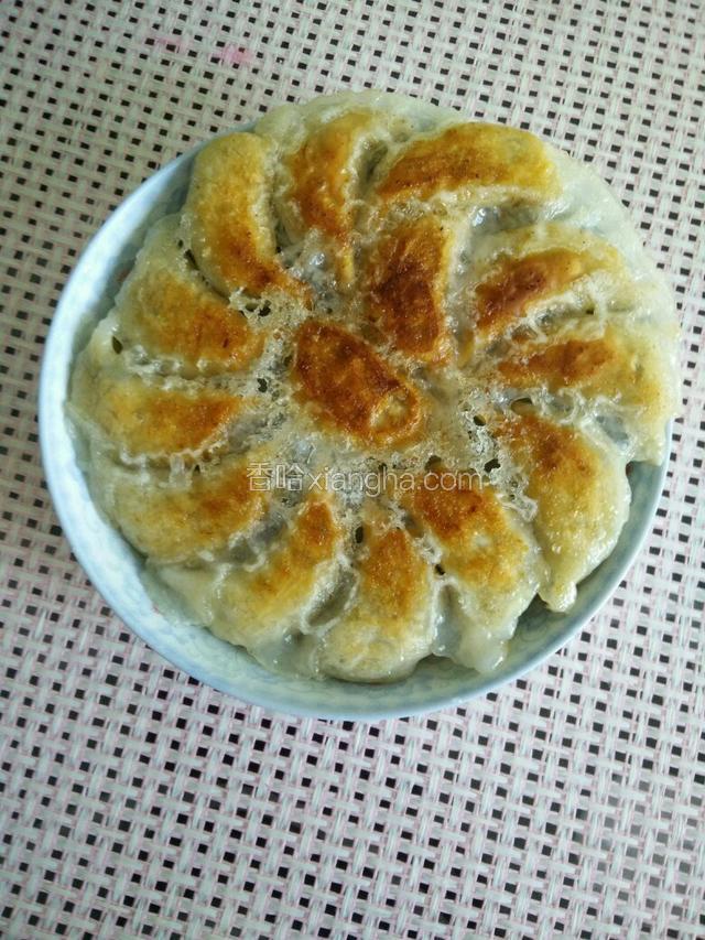 饺子底部形成薄∽的锅巴，金黄色,最后用一个大盘子倒扣在平底锅上翻转即可。
漂亮美味的冰花饺子就成功了。