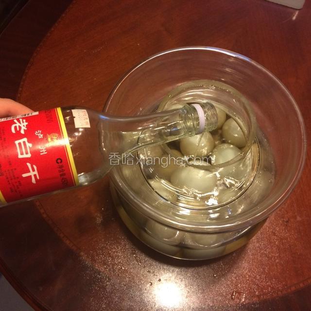 将鸭蛋小心的放入玻璃罐，注意动作要轻，鸭蛋不能破了。再将冷却好的水倒入玻璃罐，最后将白酒倒入玻璃罐。