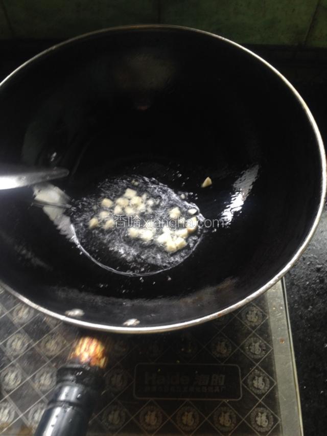 点火，将锅里水烧干，倒入适量的油，将油烧热，放去蒜粒炒出香味