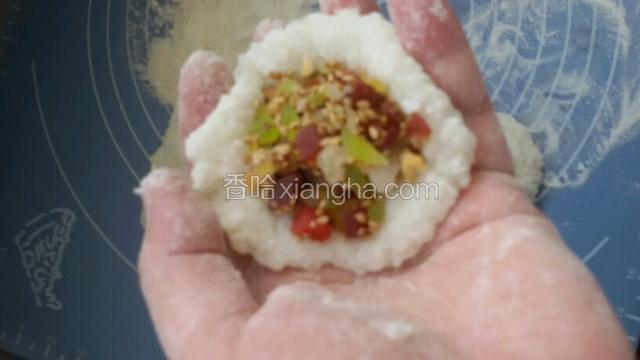 大米粉当铺面，把圆粒糯米团揪出挤，轻按开包入馅即可。