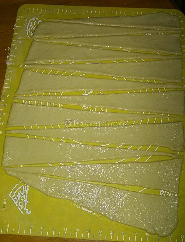刷好黄油的面片再松弛一会，切成细长13个的三角形