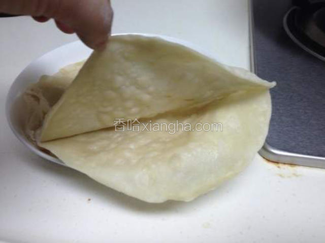 顺着当初抹油的缝隙，轻轻一扯将饼一分为二，成为薄薄的饼子