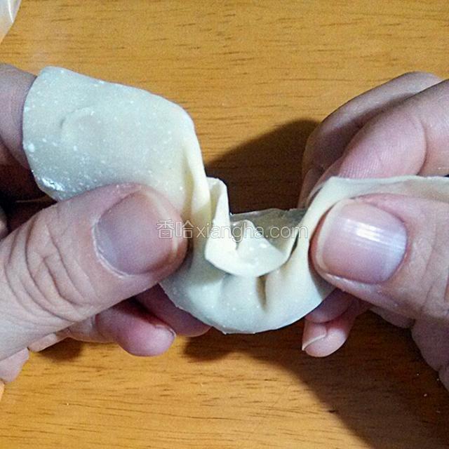双手捏住两边没有肉馅的地方