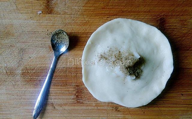 擀面杖擀成圆形(要擀的中间厚，边缘薄)，放入一小勺冻藏过的猪油和一小勺椒盐，捏紧收口