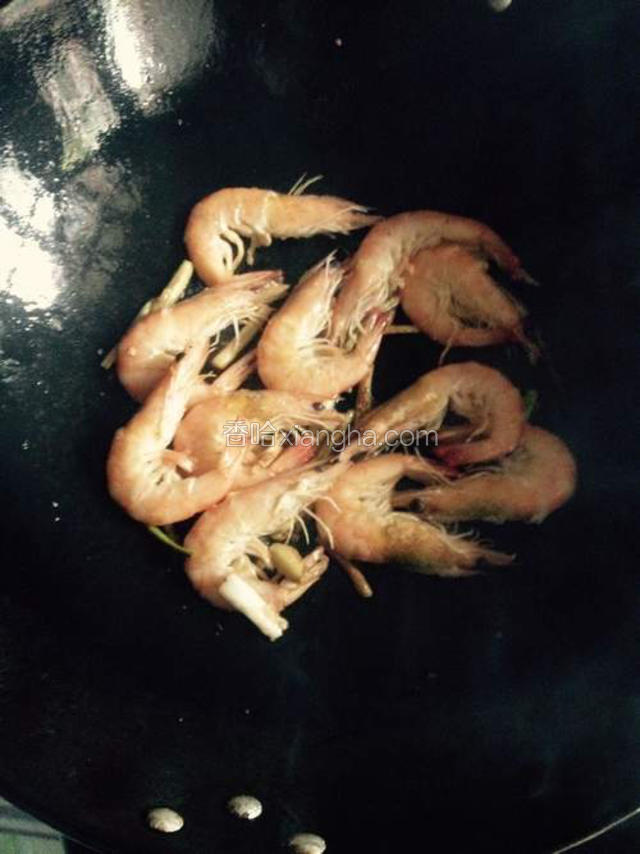 倒入大虾煎的两面金黄，加少许的盐，一点点的料酒（去腥味）少许白糖炒会