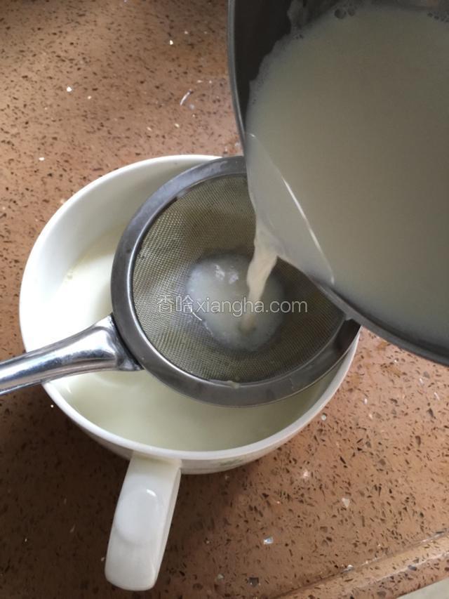 待牛奶温度降到了70度，为了吃起来口感滑些，用网筛把牛奶滤入装有姜汁的碗