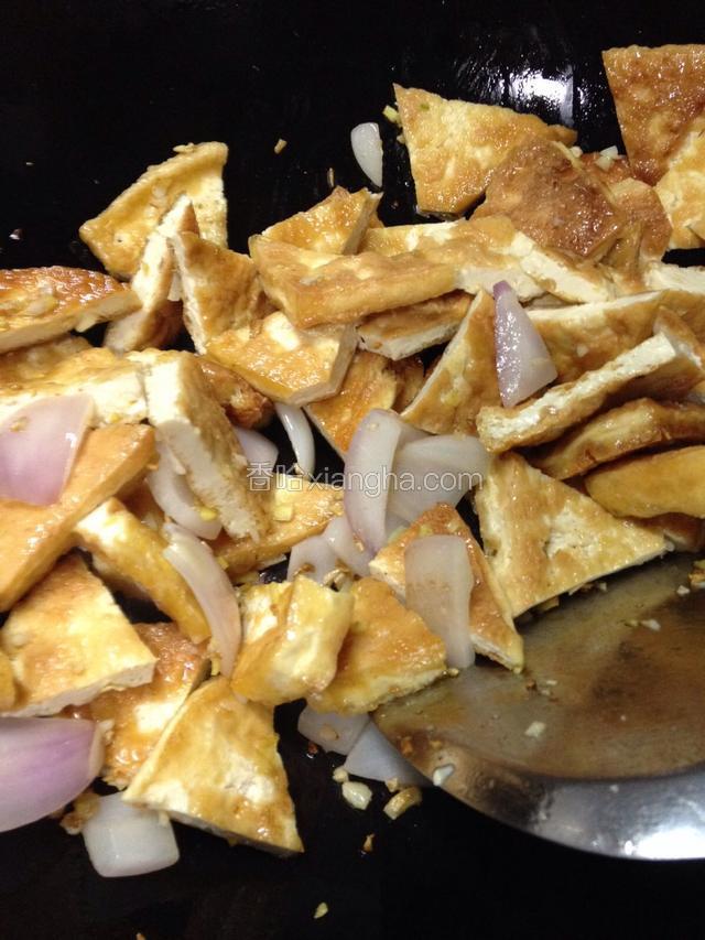 炒锅烧热倒食油，下入姜、蒜、洋葱一同炒香，下入油豆腐块炒匀，调入料酒、生抽调味。