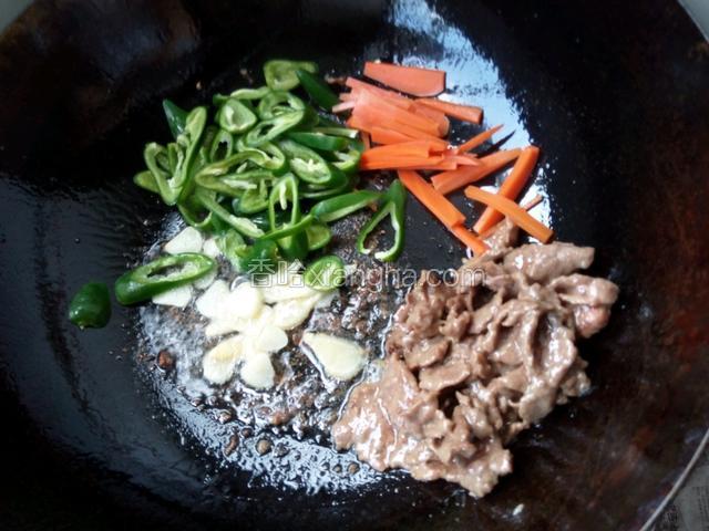 
放入牛肉翻炒3分钟，约七成熟后放入辣椒，胡萝卜，蒜，姜混炒