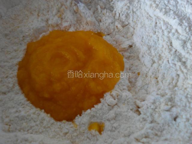 面粉里放一匙白糖5克酵母拌匀，把晾温的南瓜泥倒里，和面