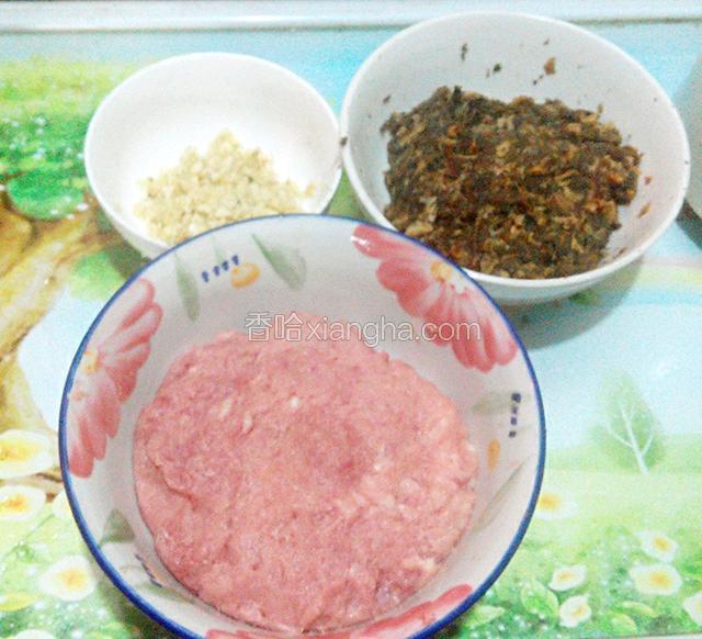 蒜头剁碎,前腿肉用绞肉机绞成肉泥(无绞肉机就用手剁吧,虽说麻烦了些,但手工剁的肉泥最好吃),菜干泡好后,洗净,剁碎备用.