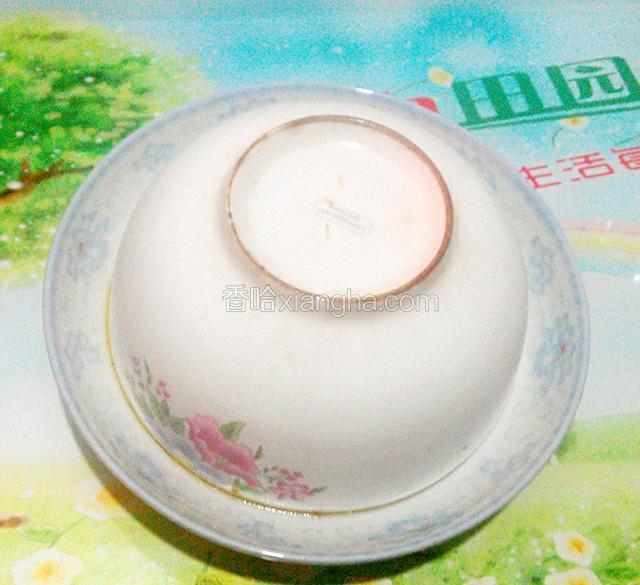 把菜干肉饼从高压锅中取出,取一盘子,盖在菜干肉饼的大碗上,倒扣过来.