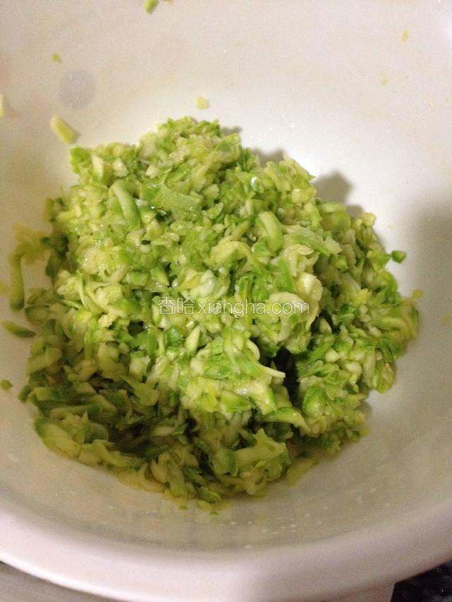 西葫芦带皮擦成丝，用盐醃十五分钟，挤去盐水(挤出的菜水留着合面)，搁切菜板上剁几刀备用。
