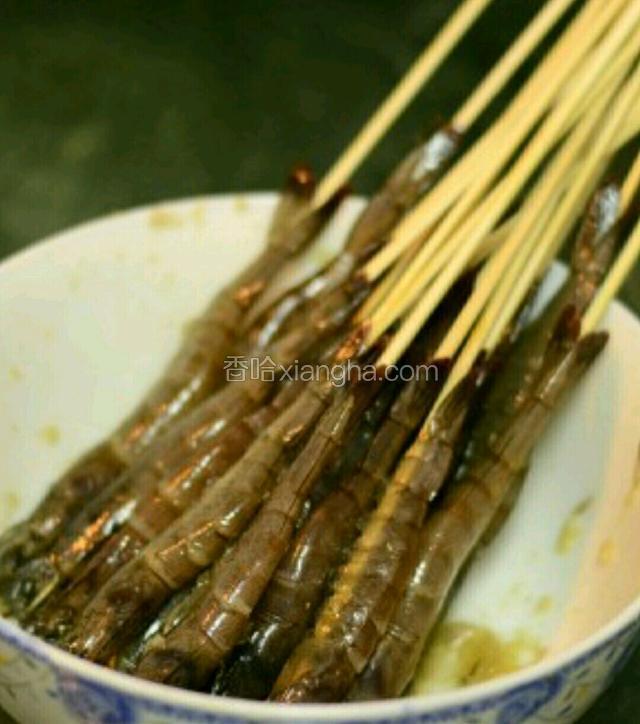 竹签泡一下温水，将腌制好的虾穿起。（也可以不用串，直接烤）
