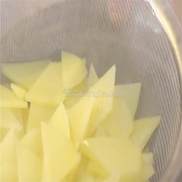 锅中加清水，大火烧开，下切好的土豆片，焯透，捞出控水备用。