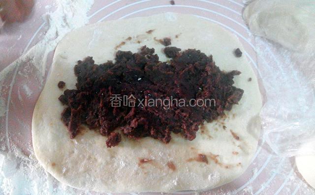 取其中一份面团,擀成方形,在上面放入红豆馅,卷起来.
