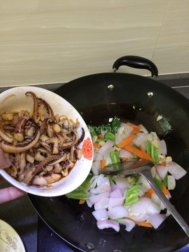 蔬菜炒至六、七成熟时加入已经腌制好的鱿鱼须继续大火翻炒。