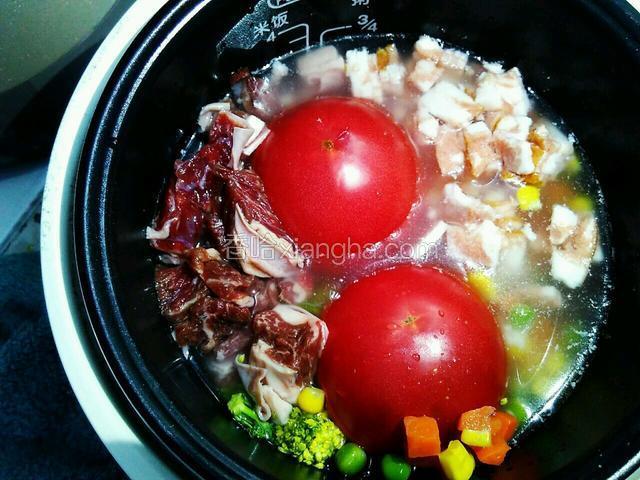 大米淘洗干净，倒入电饭煲中。加清水，清水的量要比原本煮干饭的水量少三分一。西红柿头朝下放入电饭煲里，胡萝卜丁，玉米粒，青豌豆，培根，西兰花，牛腩全部倒入电饭煲内。不需要搅拌。