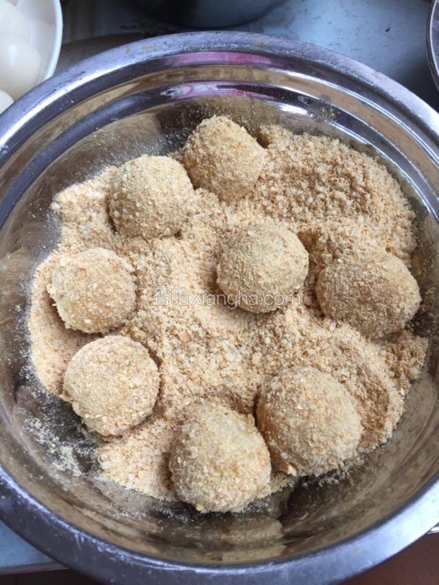 把小糯米团放入刚刚拌匀的黄豆粉中