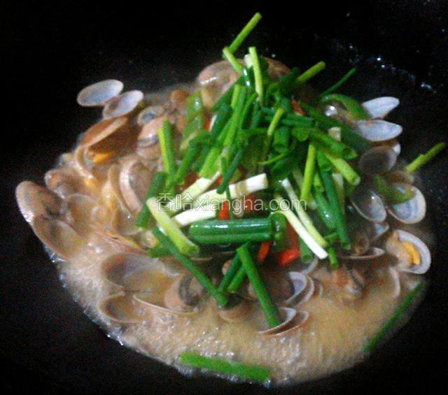 2分钟后,往锅中倒入适量清水,调入盐、生抽、鸡精,焖煮3分钟,然后倒入葱段、青红椒炒匀.