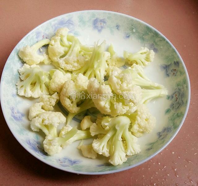 焖煮过的花菜用铲子控干水份，装盘备用。
