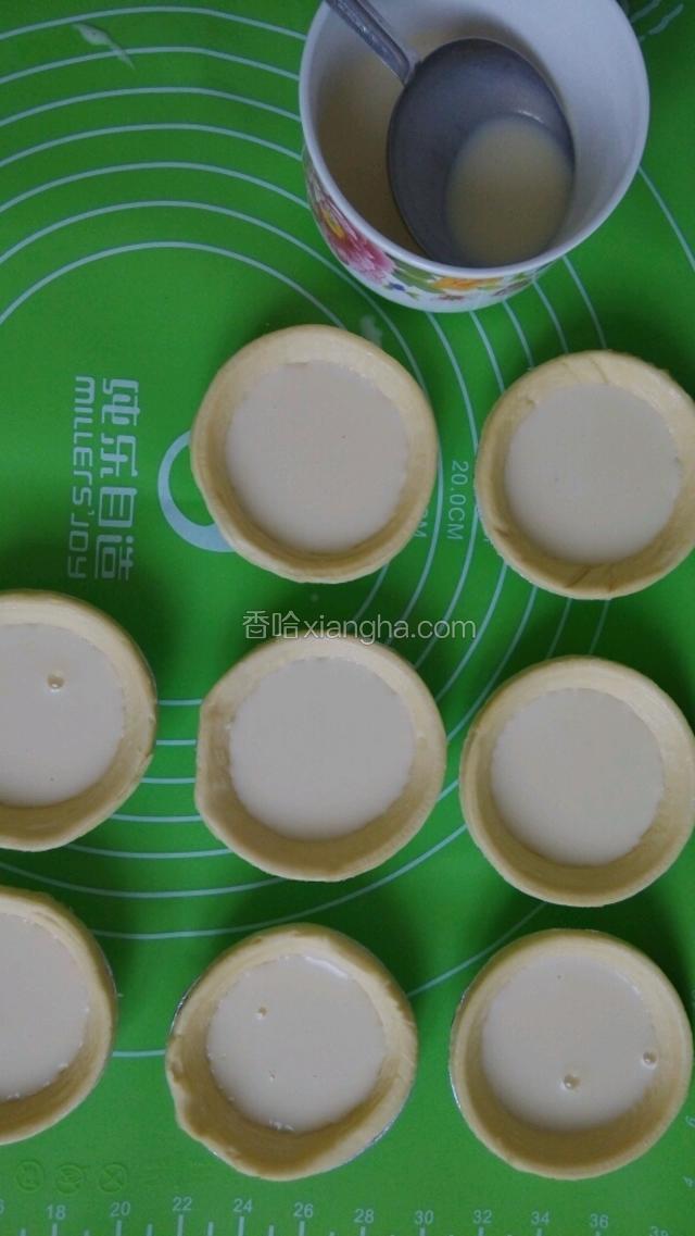 用勺子把蛋液放入挞皮中，8分满，我在里面加了猕猴桃和苹果粒