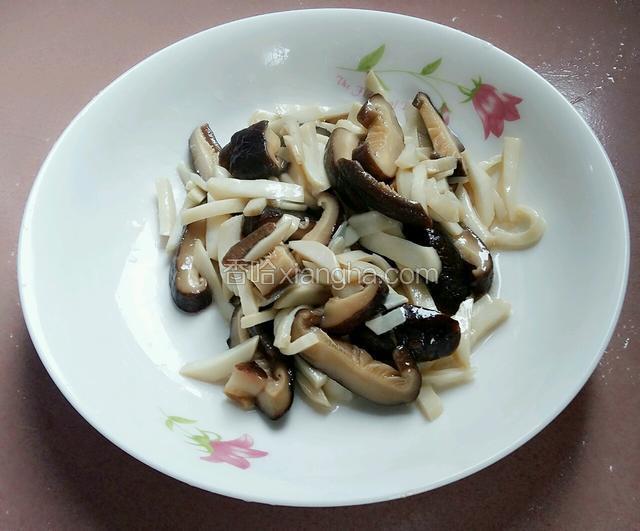 杏鲍菇香菇先用铲子控干油，再盛出装盘备用。