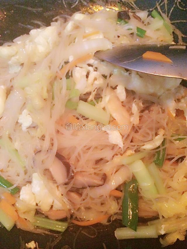 加入泡软的粉丝拌炒，记得加一点点水，不然太干，加入葱段。倒入鸡蛋饼，快速翻炒。