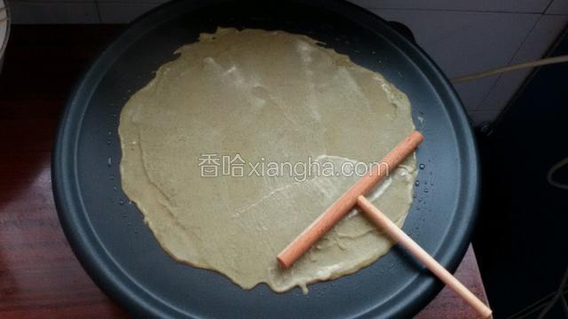 提前预热薄饼机，用勺子舀适量面糊，在用推板推平