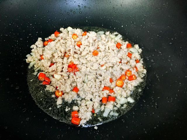 加进小米椒结、蒜粒炒出香味。