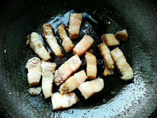 炒至五花肉变色发白，加入半勺料酒，继续翻炒一会。盛出，待用。