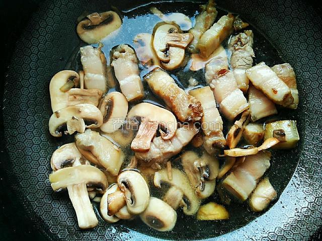 加入清水，以盖过蘑菇和五花肉为佳。水烧开后加入一勺生抽，两勺老抽，一勺白糖，一勺料酒。