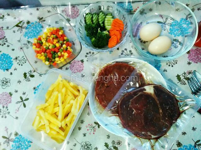 准备食材。如下。
牛排2块（买的是成品）、鸡蛋2颗、提前用花格刀切成薄片的黄瓜和胡萝卜、焯过水的西兰花朵、玉米粒、青豆、切好的胡萝卜丁、提前处理好的薯条。
