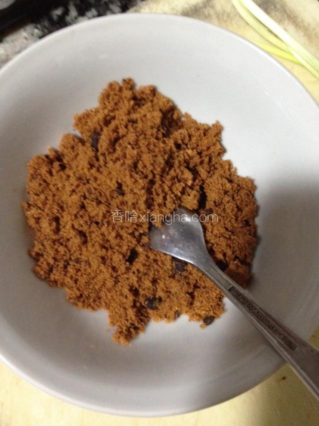 取出红糖装小碗内用勺子压碎。