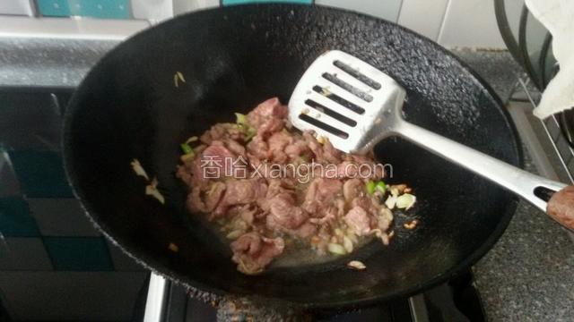 热锅凉油，等油热下入葱，姜和羊肉片煸炒至段生