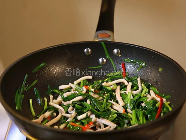加入鲜鱿鱼和红椒丝，再添加盐、味精、白糖、胡椒粉和料酒大火翻炒几下，最后淋上香油出锅。