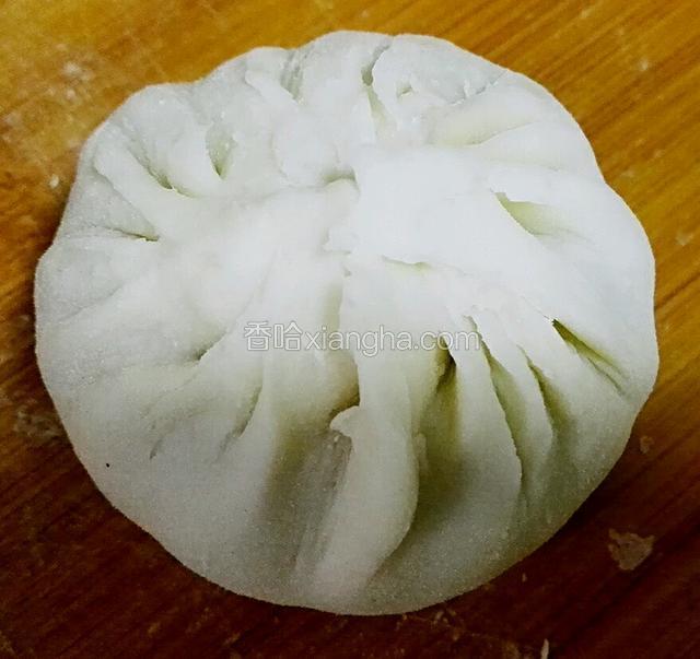 取一份擀成中间厚四周薄的皮子，把馅装在中间，捏紧封口
