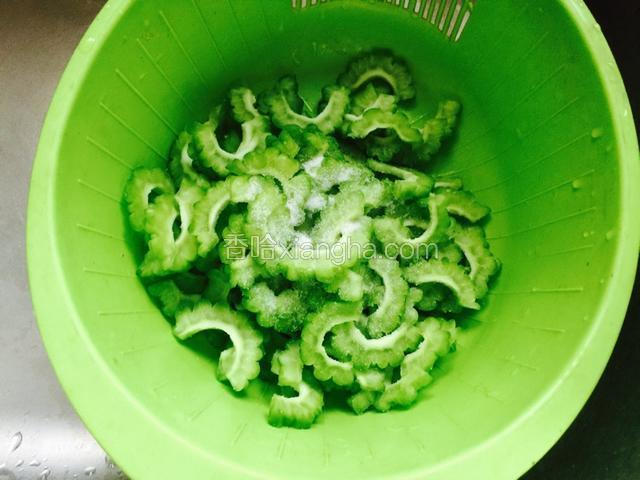 苦瓜片撒盐腌制8-10分钟。