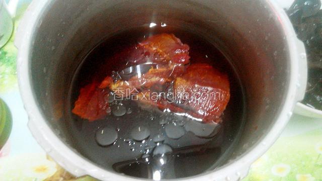 取一高压锅,放入洗净的牛肉,加入清水,调入芝麻油、盐、生抽、老抽,盖上高压锅盖子,开大火,锅上汽转小火,煲40分钟.