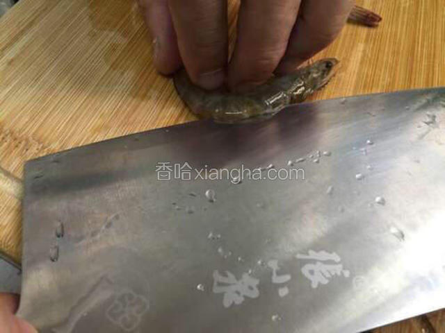 用刀画开虾背，取出虾线，斜入刀，往下轻按刀刃朝虾尾划拉