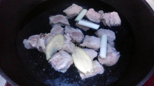 锅中重新添水放入排骨，葱段和姜片，水量要没过排骨，开大火炖开锅后转小火炖煮三十分钟。