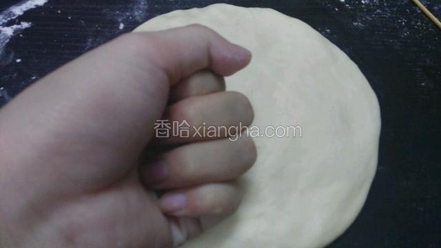 把面团放在案板上 用手捶出里面的空气